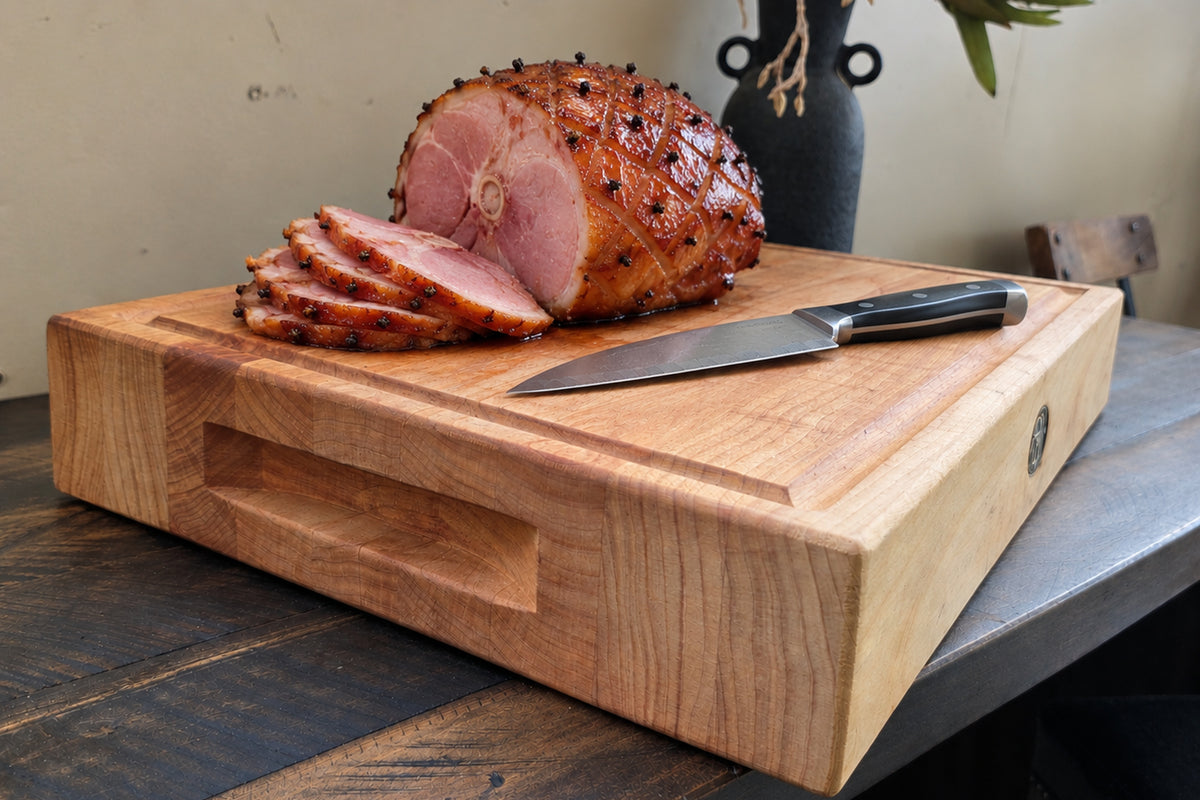 Christmas ham carved on a macrocarpa chopping board with a knife